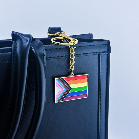 Progressive Pride Flag Keychain on a hand bag