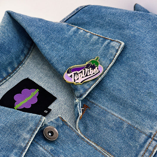 Top Vibes Enamel Pin that has a big eggplant on the back and top vibes written in the middle