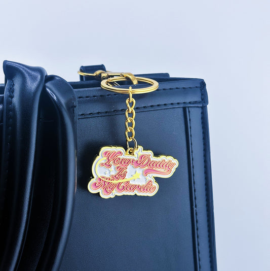 The key chain that has Your daddy is my cardio written on which is hung on the bag 
